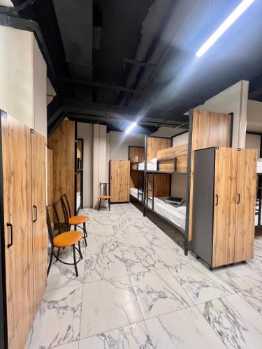 Habitación grande con paredes de madera, sillas y mesas. en Mega Hostel, en Almaty