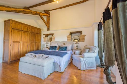 1 dormitorio con 1 cama grande y 2 sillas en Domaine de Roujol, en Brassac