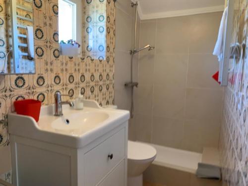 a bathroom with a sink and a toilet and a tub at Andar tranquilo entre Lisboa Sintra in Sintra