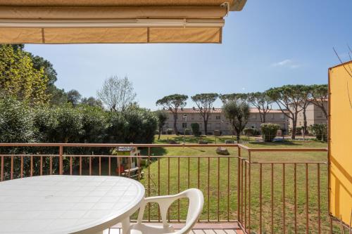 a table and chairs on a balcony with a view of a park at Apartamentos CASA MAREA La Fosca parking y piscina in Palamós