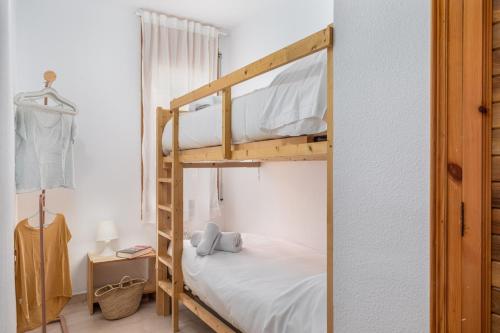 a bedroom with two bunk beds and a mirror at Apartamentos CASA MAREA La Fosca parking y piscina in Palamós