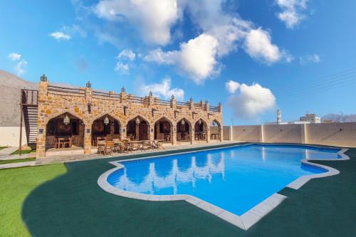 a large swimming pool in front of a building at Esra Hotel Apartment in Khasab