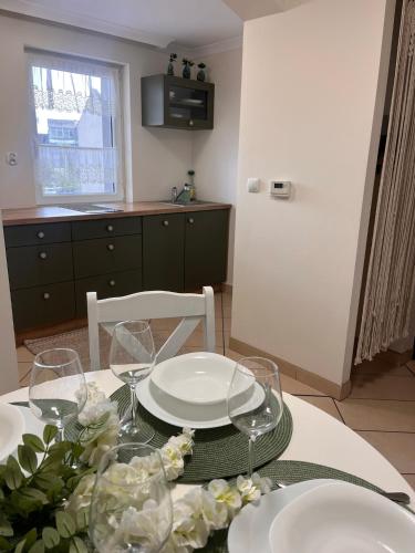 a dining room table with plates and glasses on it at Apartament na Starówce Boho in Pszczyna