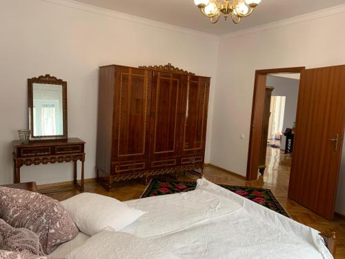 sypialnia z łóżkiem, komodą i lustrem w obiekcie Casa Toma M w mieście Baia Mare