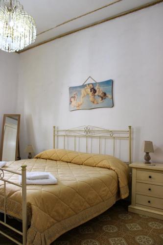 a bedroom with a bed and a painting on the wall at Casa Vacanze "A Machina Ro Ghiaccio" in Noto
