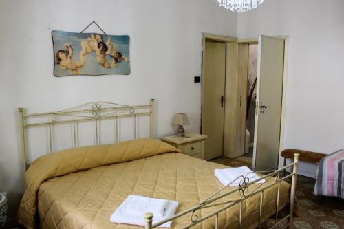 a bedroom with a bed and a painting on the wall at Casa Vacanze "A Machina Ro Ghiaccio" in Noto