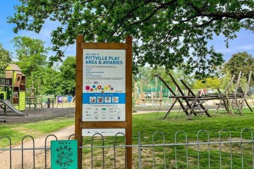 a sign in a park with a playground at Stunning modern 2 bedroom, 2 bathroom townhouse in Cheltenham