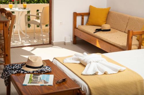 Zimmer mit einem Bett und einem Tisch mit Hut in der Unterkunft Aphrodite Apartments in Kalyves