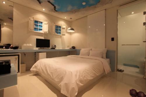 a bedroom with a white bed and a desk at Hotel Pop2 Jongno in Seoul