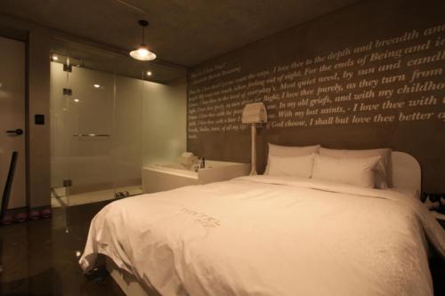 a bedroom with a white bed and a writing wall at Hotel Pop2 Jongno in Seoul