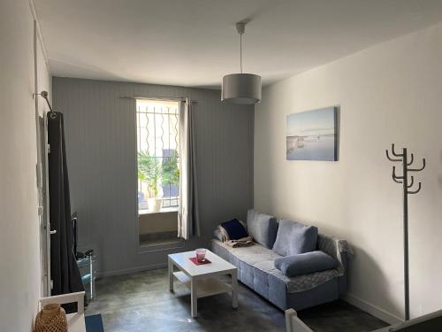 un salon avec un canapé et une table dans l'établissement Studio indépendant dans maison de ville, au calme, à Marseille