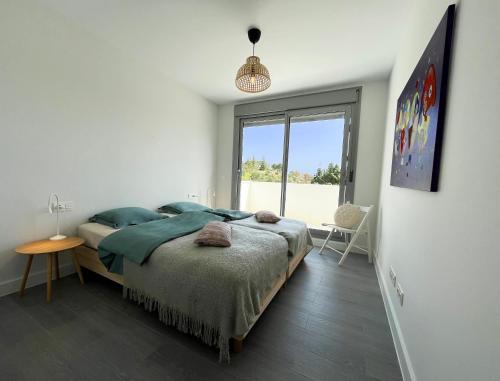 Habitación blanca con cama y ventana en Wonderful, excellent new 4-bed apartment near Málaga with indoor and outdoor swimmimg pools, gym and sauna facilities, en Mijas Costa
