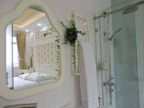 baño con espejo, cama y ducha en Chez Lotus Rose, en Ho Chi Minh