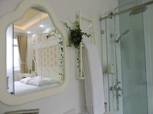 Un baño con espejo y cama y ducha. en Chez Lotus Rose, en Ho Chi Minh