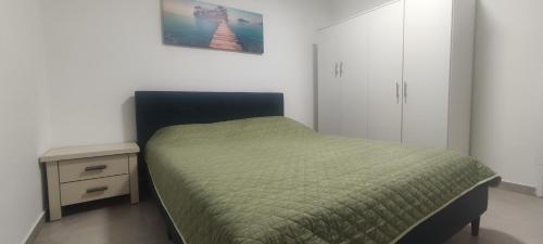 ein Schlafzimmer mit einem grünen Bett und einem Nachttisch in der Unterkunft Yona balev in Eilat