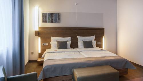 a bedroom with a large bed with a wooden headboard at Hotel Stadtpalais in Cologne