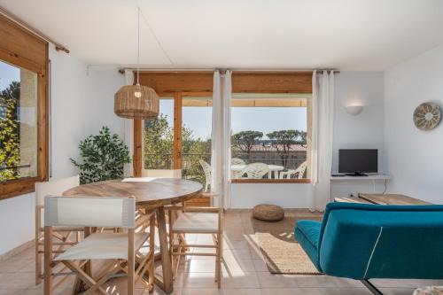 a kitchen and dining room with a table and chairs at Apartamentos CASA MAREA La Fosca parking y piscina in Palamós