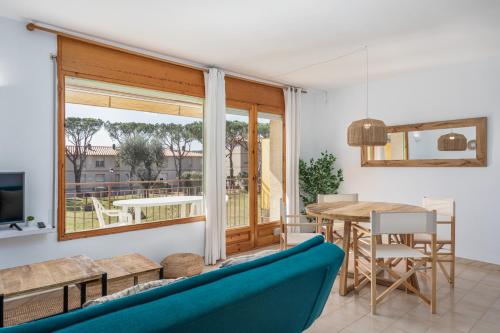 a living room with a blue couch and a table at Apartamentos CASA MAREA La Fosca parking y piscina in Palamós