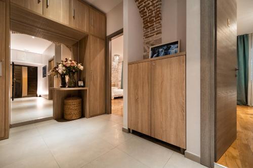 um corredor com paredes de madeira e uma porta com um vaso de flores em Tifani Luxury Rooms em Split