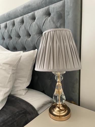 a lamp sitting on a table next to a bed at Apartamenty Vincent Sopot in Sopot