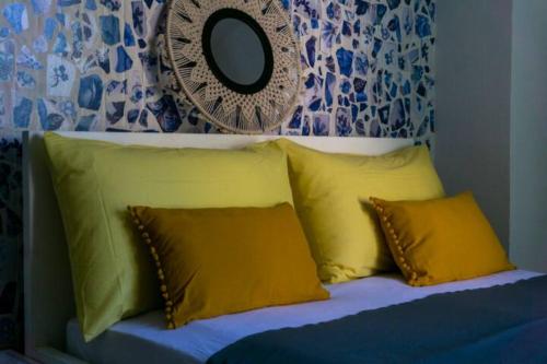 1 cama con 3 almohadas amarillas y espejo en Guesthouse Lion, en Split
