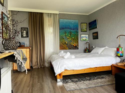 a bedroom with a large bed and a painting on the wall at Artist's Cellar in Tʼelavi