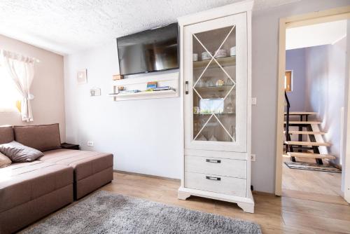 Žirovnica的住宿－Guest House Pr' Čut，客厅配有白色橱柜和沙发