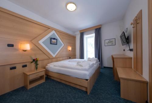 a bedroom with a large bed in a room at Hotel Italia in Castello di Fiemme