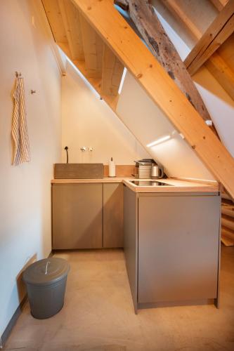 an attic kitchen with a sink and a stove at B&B Le Rêve Maastricht in Maastricht