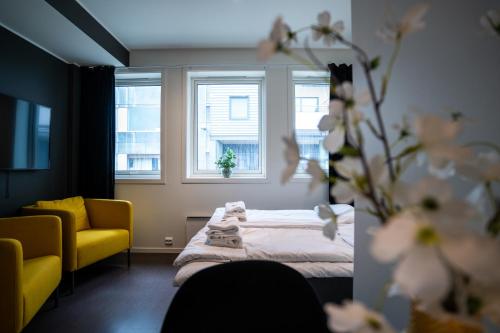 Habitación con cama, silla y ventanas. en TA Seminarbakken City Studio en Tromsø