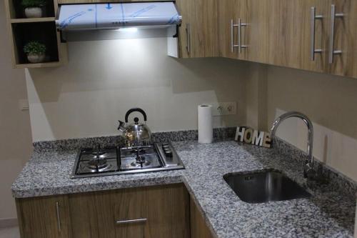a kitchen counter with a sink and a stove at Cosy Apartment in Oualidia City Centre with Free WiFi in Oualidia