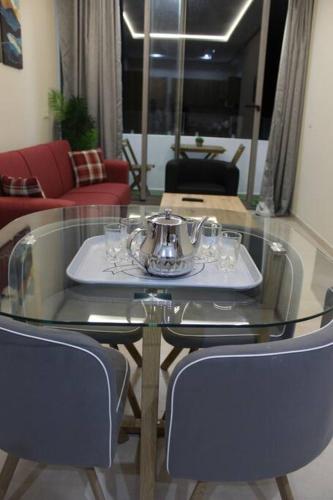 a glass table with a tea set on it in a living room at Cosy Apartment in Oualidia City Centre with Free WiFi in Oualidia
