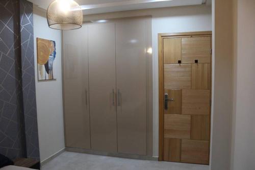 a closet with a glass door in a room at Oualidia City Centre Cosy Apartment, Free WIFI in Oualidia