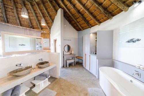 a bathroom with two sinks and a tub at Thonga Beach Lodge in Mabibi