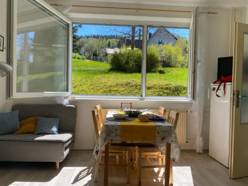 comedor con mesa y ventana grande en Slunný byt v Jizerských horách 5 postelí en Tanvald