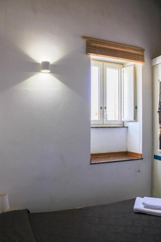 a light on a wall next to a window at Casa Vacanze "A Machina Ro Ghiaccio" in Noto