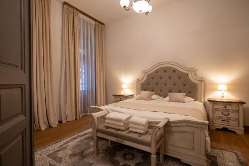1 dormitorio con 1 cama grande, 2 mesitas de noche y ventana en Kinsley Apartment 1, en Timisoara
