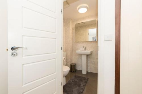 a bathroom with a toilet and a sink at Greenfield's Marlborough Grove Modern 3 - Bedroom Home, Langley in Langley Marish