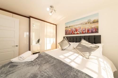 um quarto com uma cama e um quadro na parede em Greenfield's Marlborough Grove Modern 3 - Bedroom Home, Langley em Langley Marish