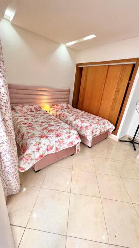two beds sitting in a room with at Tanagra Mall appartement de Luxe a côté de la Gare TGV in Kenitra