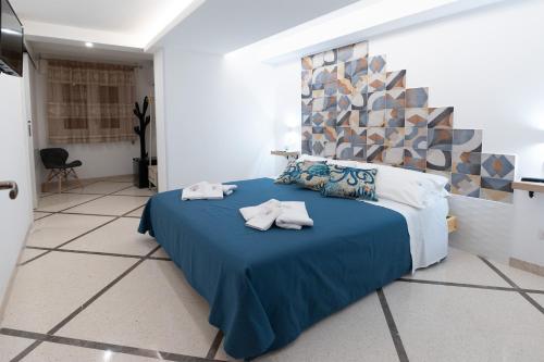 Un dormitorio con una cama azul con toallas. en B&b Essence Ispica, en Ispica