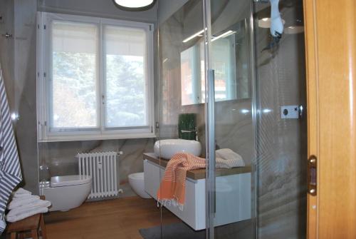 a bathroom with a toilet and a glass shower at Suite 51 Appartamento con terrazzo a 50 mt dal lago - Private Parking in Arona