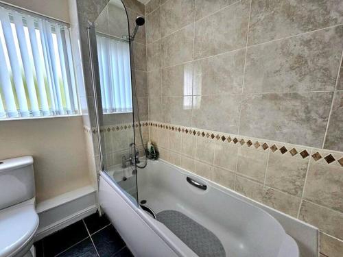 a bathroom with a shower and a tub and a toilet at Baltic Gem 4 Bedroom Townhouse with free parking in Liverpool