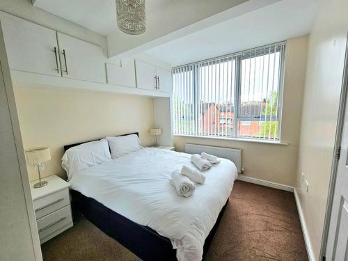 a bedroom with a large white bed with towels on it at Baltic Gem 4 Bedroom Townhouse with free parking in Liverpool