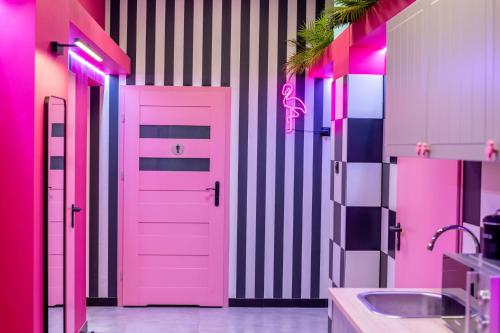 a pink bathroom with a pink door and a sink at VICE CITY Hostel in Wrocław