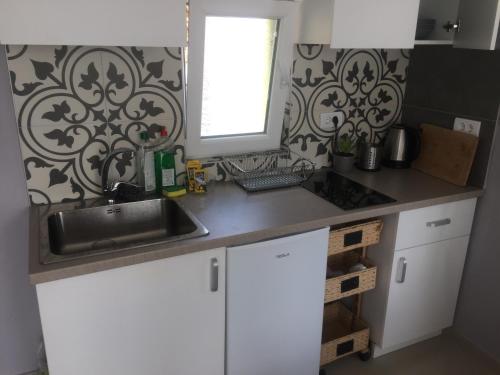 a kitchen counter with a sink and a window at Bungalow Lux in Novi Banovci