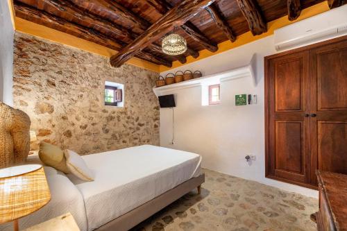 um quarto com uma cama e um armário de madeira em Can Mateu em Santa Eulària des Riu