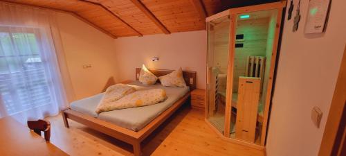 a small bedroom with a bed and a glass shower at Residence Alpina in Santa Maddalena in Casies