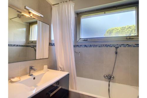 ein Bad mit einem Waschbecken, einem Fenster und einer Dusche in der Unterkunft L'Ermitage - Happy Rentals in Antibes