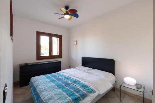 a bedroom with a bed and a ceiling fan at Water Front Scopello in Scopello